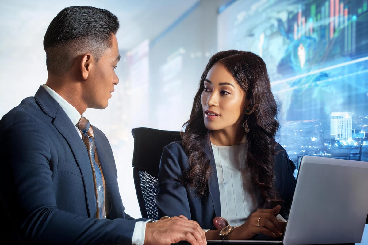 Two people at a desk discussing SEO in front of a computer